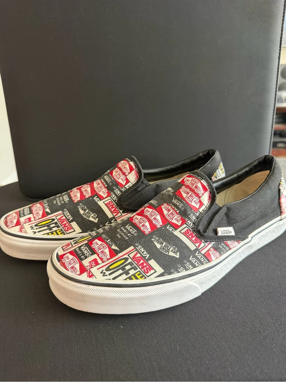 Vans Slip-On Sneakers in Black, White & Red Logo Print